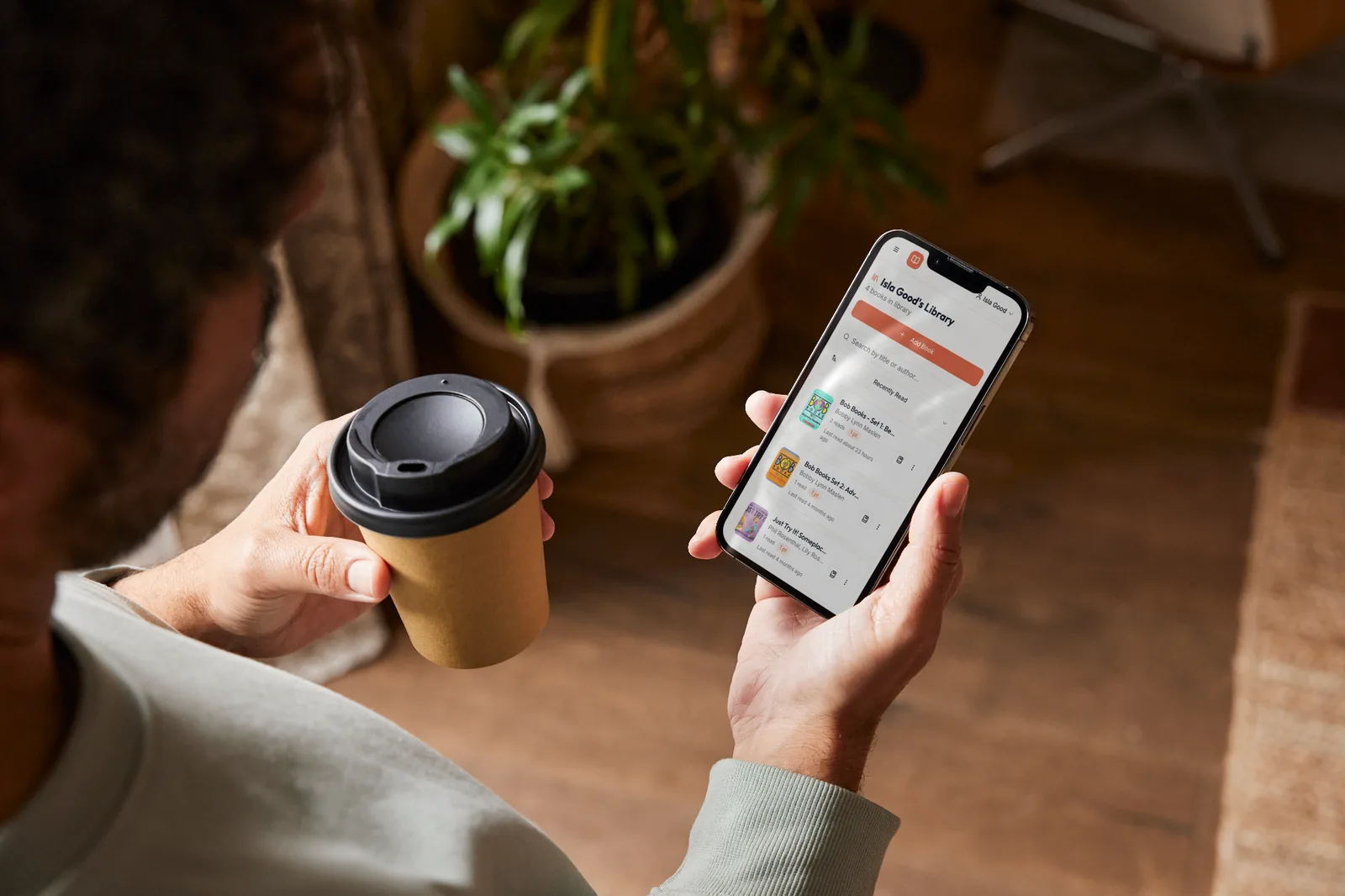 Person with coffee browsing their Readloops book library on a phone